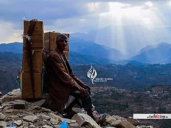 An old man struggling his way up the mountain heavily loaded to make sure that his received food! (Courtesy of facebook.com/EndTaizSiege) 