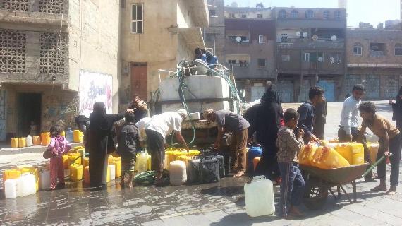 Children and adults getting water from water truck