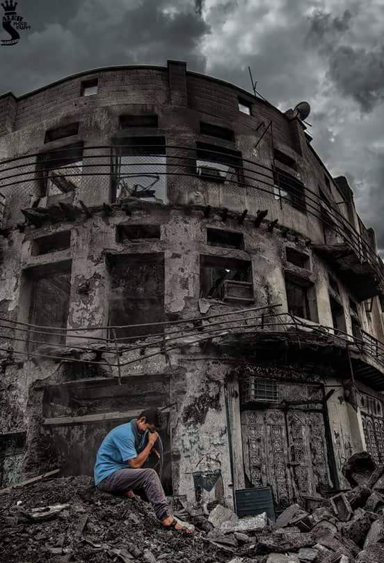 Tariq weeps outside of destroyed residential building in Taiz he had been living in.