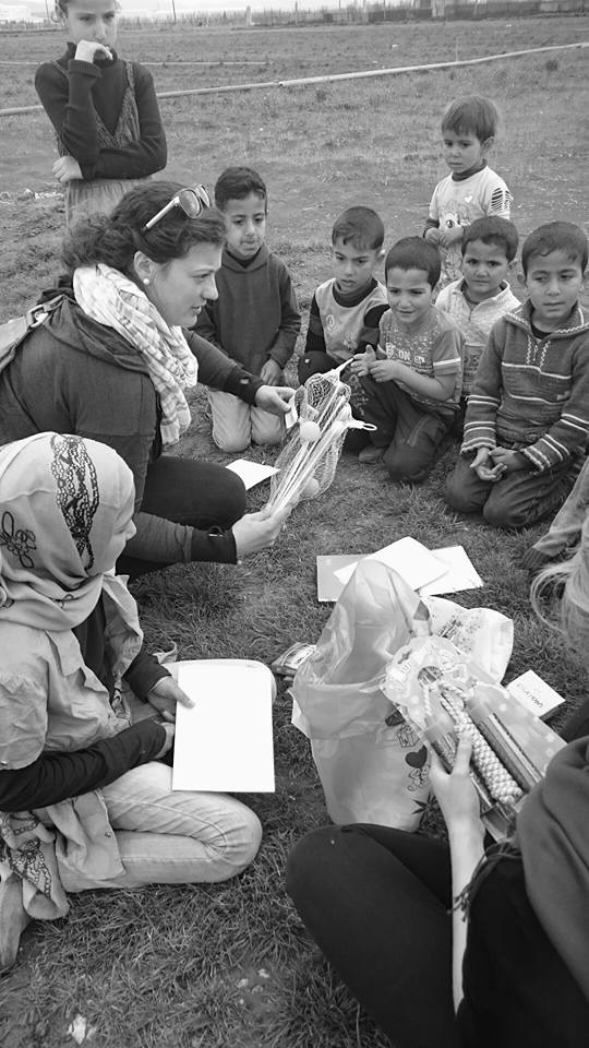 Volunteers playing with young Syrian refugee children