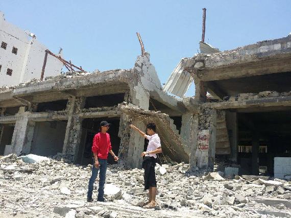 Our reporter being shown by a resident the damage done to buildings in Aden from the armed conflict