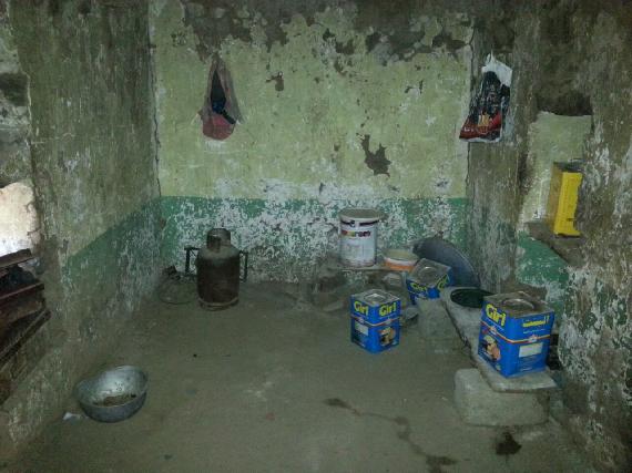 The kitchen inside the house with gas cylinder visible.