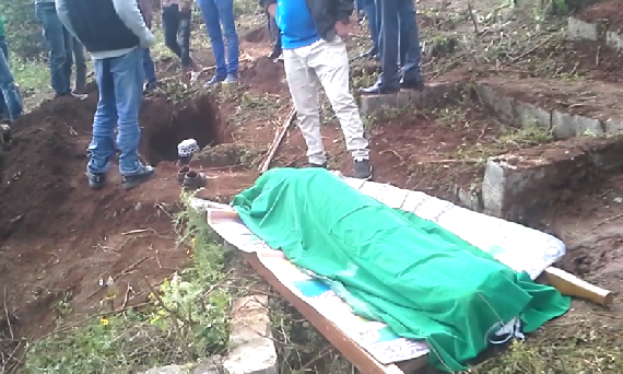 Unidentified refugee being buried who died in the camp